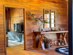 a kitchen with a wooden wall with a sink and a mirror at Villa Vida Cabanas in São Joaquim +122 photos