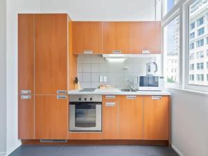 cocina con armarios de madera y fogones en Lively and Stunning Central Apt by Zodiak Stays, en Auckland
