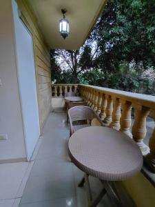 - un balcon avec une table et des chaises sur une terrasse couverte dans l'établissement Pearl pyramids Inn, au Caire