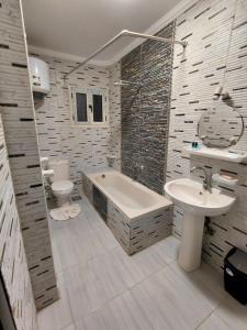 une salle de bain avec une baignoire, des toilettes et un lavabo dans l'établissement Pearl pyramids Inn, au Caire