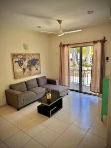 a living room with a couch and a table at Depa 102A en Huatulco con alberca y terraza 5 min playa in Santa Cruz Huatulco