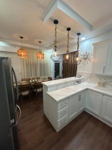 a kitchen with white cabinets and a dining room at NEW Villas Milas a few steps from Tela beach in Tela