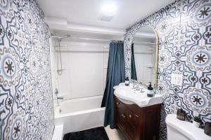 a bathroom with a sink and a tub and a mirror at Retro 2 bedroom basement APT with free parking in New Rochelle