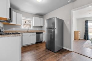 una cucina con frigorifero in acciaio inossidabile e mobili bianchi di Stylish 1-Bedroom Retreat in Fort Worth a Fort Worth