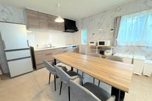 a kitchen with a long wooden table and chairs at Grande Ortho Okinawa Villa Onna 3 - Vacation STAY 91376 in Onna