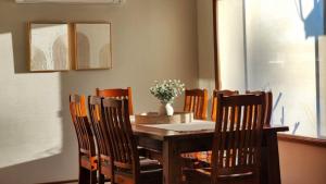 a dining room table and chairs with a vase on it at A Slice Of Paradise in Sussex inlet