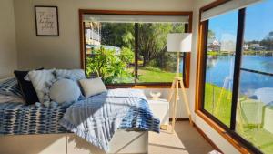 a bedroom with a bed and a large window at A Slice Of Paradise in Sussex inlet +12 photos