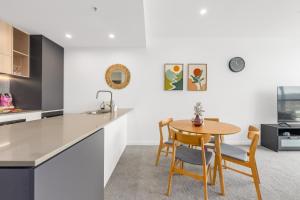 a kitchen and dining room with a table and chairs at Cosy Woden Apt Near Canberra Hospital,Transport in Phillip
