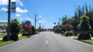 an empty street with trees and pink flowers at Jopen Motel Unit 3 in Sussex inlet