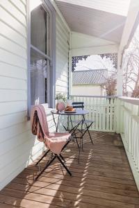 a patio with a table and chairs on a porch at Home on Macfie St in Devonport