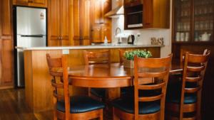 a kitchen with a wooden table and four chairs at Riverfront Retreat Sussex House Park in Sussex inlet