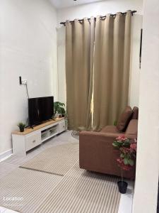 a living room with a couch and a television at Aisyah Homestay in Kuala Ketil +4 photos