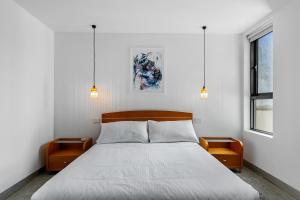 a bedroom with a large bed with two night stands at Vibrant 2-Bed Apartment Near St Kilda Beach in Melbourne +5 photos