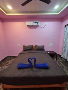 een bed met een blauw lint eraan in een kamer bij Swayambhu Resort in Malvan