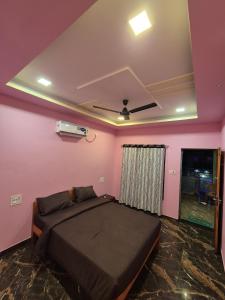 een slaapkamer met een bed en een roze muur bij Swayambhu Resort in Malvan