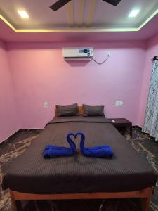 een bed in een kamer met twee blauwe pantoffels bij Swayambhu Resort in Malvan