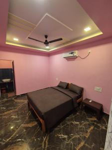 een slaapkamer met een bed in een roze muur bij Swayambhu Resort in Malvan +1 foto