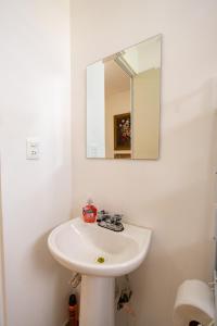 a bathroom with a white sink and a mirror at Family Home with Pool, El Mirador 2 Bedrooms in Tlayecac