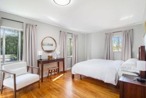 a bedroom with a bed and a mirror and a chair at Heart of Ann Arbor Stay in Ann Arbor