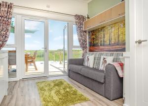 a living room with a couch and sliding glass doors at Celtic Escapes in Narberth +4 photos