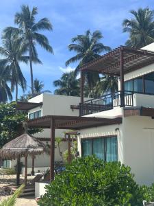 Tha SalaChansi Beachresort的棕榈树掩映的海滩上的房子