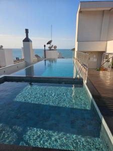 a swimming pool with a view of the ocean at Suite privada en Four Seasons Residence monoambiente in Bombinhas
