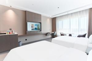 um quarto de hotel com duas camas e uma TV em Harbin Airport Lake View Hotel em Harbin mais 62 fotografias