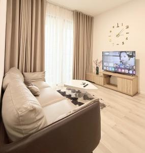 a living room with a couch and a flat screen tv at Căn hộ 2 phòng ngủ Vinhomes Grand Park, Hồ Chí Minh city in Gò Công