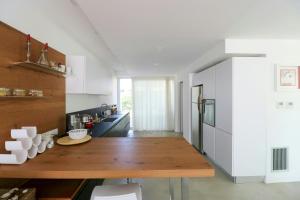 a kitchen with a wooden table and a refrigerator at Modern Villa With Views Of Ortigia in Carrozziere – Fonte Ciane