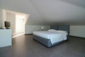 a bedroom with a white bed and a television at Modern Villa With Views Of Ortigia in Carrozziere – Fonte Ciane +12 photos