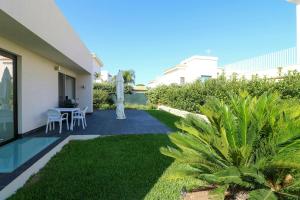 a garden with a table and chairs in a house at Modern Villa With Views Of Ortigia in Carrozziere – Fonte Ciane