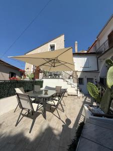 a table and chairs with an umbrella on a patio at Casa Particolari nel Cilento in Giungano