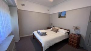 Un dormitorio con una cama con sábanas y almohadas blancas. en Cottage 2 Sussex House Holiday Park, en Sussex Inlet