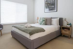 Un dormitorio con una cama con un osito de peluche encima. en Dolce Vita Esplanade NobleBNB, en Port Willunga 32 fotos más