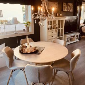 Una mesa de comedor con sillas y un televisor. en Sentral leilighet, nært tog, buss, sykehus og byen, en Bodø