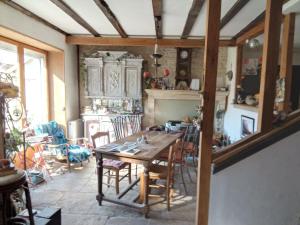 a dining room with a wooden table and chairs at La Grille Fleurie, chambres d'hôte chez l'habitant in Arthonnay
