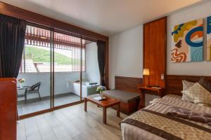 ein Hotelzimmer mit einem Bett und einem großen Fenster in der Unterkunft The Sky & Sea Koh Larn in Ko Larn + 57 Fotos