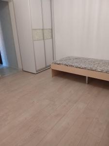 a bedroom with a bed and a wooden floor at Ботанічний Сад in Kharkiv