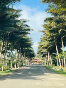 a palm tree lined street with a building in the distance at Casa Vacacional Valles de Olon in Santa Elena