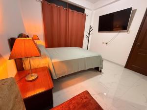 a bedroom with a bed and a table with a lamp at Casa Vacacional Valles de Olon in Santa Elena +20 photos