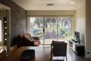 a living room with a couch and a window at Morze Beach, Currarong in Currarong
