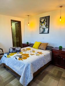 a bedroom with a bed with a yellow and blue blanket at Casa Sac Nicte Tlalpujahua in Tlalpujahua de Rayón