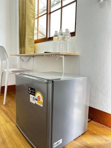 a small refrigerator with a shelf on top of it at Ct House in Chiang Mai