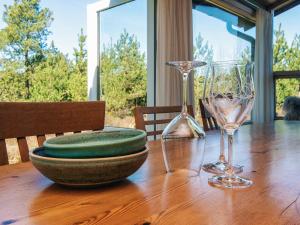 a wooden table with two wine glasses on it at 6 person holiday home in Rømø in Bolilmark +25 photos