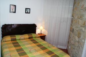 1 dormitorio con 1 cama y 1 lámpara en una mesa en Casa Yayo, en La Pobla de Benifassà (Puebla de Benifasar)