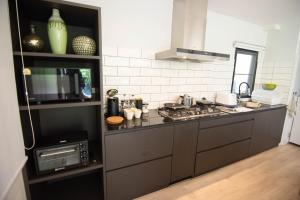 a kitchen with a stove and a microwave at Villa Kanya Aonang in Ao Nang 