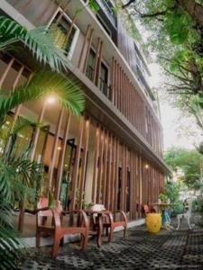 a building with tables and chairs in front of it at BB House Mini Suite Hotel in Ban Zong Katiam