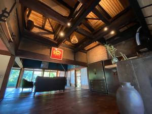 a living room with a table and a vase on the floor at 武家屋敷 無為自然ーSamurai House in Yunoo