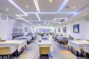 a dining room with white tables and chairs at James Joyce Coffetel·Anyang Text Museum in Anyang