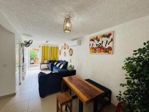 a living room with a blue couch and a wooden table at Casa con alberca cerca de playas in Ixtapa